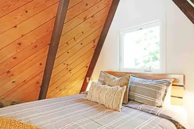a bedroom with a bed with a wooden ceiling at Mid Century Modern Cabin - The Tahoe A-Frame in Homewood
