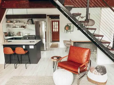 a kitchen with a counter and a chair in a room at Mid Century Modern Cabin - The Tahoe A-Frame in Homewood