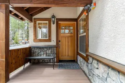 a porch of a house with a wooden door and a bench at Bright 3BD Kings Beach Townhome in Kings Beach