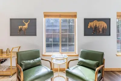 a living room with two chairs and a deer on the wall at Bright 3BD Kings Beach Townhome in Kings Beach