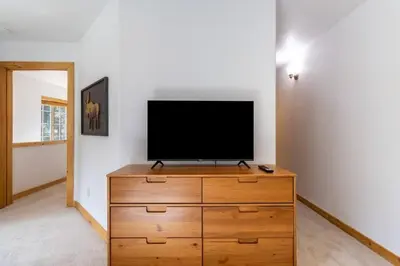 a flat screen tv sitting on top of a wooden dresser at Bright 3BD Kings Beach Townhome in Kings Beach