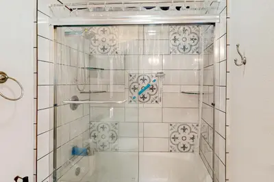a shower with a glass door in a bathroom at Zen Amongst the Trees in Truckee