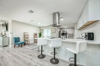 a kitchen with two white chairs and a counter at Fun City Haven Spacious Retreat in Fresno in Fresno
