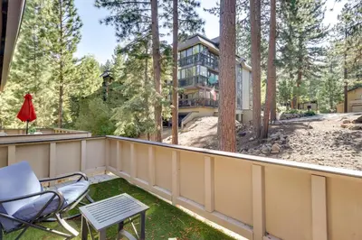 a balcony with chairs and a house in the woods at Stylish Incline Village Vacation Rental with AandC! in Incline Village
