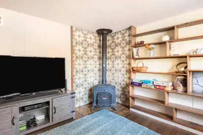 a living room with a tv and a wood stove at Murphys Wine Country Getaway in Murphys