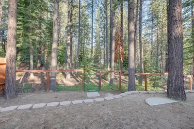 a wooden fence in a forest with trees at Hike, Boat and Ski South Lake Tahoe Home in South Lake Tahoe