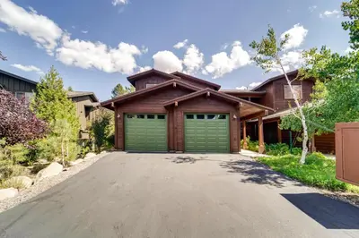 a house with green garage doors on a driveway at Boulders Truckee Condo Near Donner Lake and Skiing! in Truckee