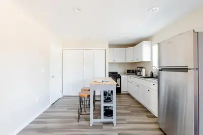 a kitchen with white cabinets and a stainless steel refrigerator at Beautiful spacious guest home in Roseville