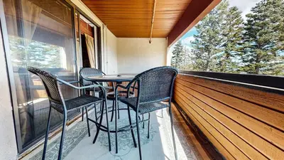 a porch with chairs and a table on a balcony at Bridges #108 condo in Mammoth Lakes