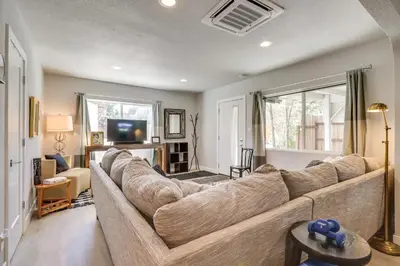 a living room with a large couch and a tv at MidTown Reno Vacation Rental with Fenced-In Yard! in Reno