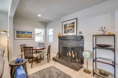 a living room with a fireplace and a table at MidTown Reno Vacation Rental with Fenced-In Yard! in Reno