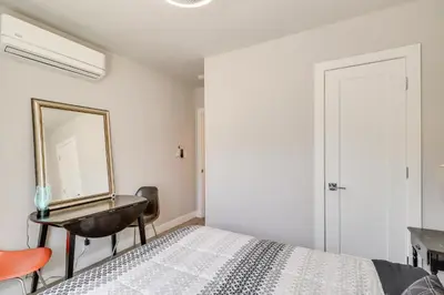 a bedroom with a bed with a mirror and a desk at MidTown Reno Vacation Rental with Fenced-In Yard! in Reno