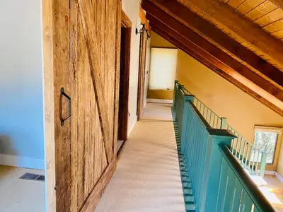 a hallway of a building with a wooden door and stairs at Sequoia Cabin by the River in Three Rivers