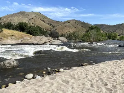 a river with rocks and mountains in the background at Sequoia Cabin by the River in Three Rivers