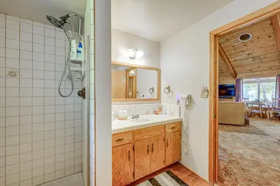 a bathroom with a sink and a shower and a mirror at Countryside Views Family-Friendly Badger Cabin in Badger