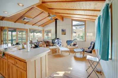 a kitchen and living room with wooden ceilings at Scenic Kernville Getaway with Deck and Mountain Views! in Kernville