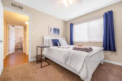 a bedroom with a white bed and a window at Longer Stays for Travelers- Apt Blocks from Hospital, Downtown in Visalia