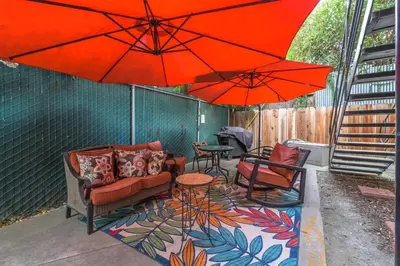 a patio with umbrellas and chairs and a table at Longer Stays for Travelers- Apt Blocks from Hospital, Downtown in Visalia