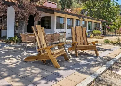 two wooden chairs and a table in front of a house at Scenic Spanish Rancho - Breathtaking Views in Three Rivers