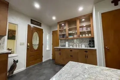 a kitchen with a cat sitting in front of a door at Creekside Suite Sleeps 2 Creek frontage Bbq in Oakhurst