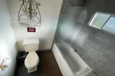a bathroom with a toilet and a bath tub at Creekside Suite Sleeps 2 Creek frontage Bbq in Oakhurst