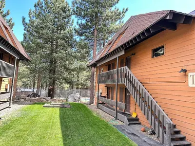 a house with a grass yard next to a building at La Residence V #T05 condo in Mammoth Lakes