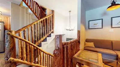 a living room with a staircase and a couch at Chamonix #64 condo in Mammoth Lakes