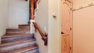 a hallway with stairs and a door with a branch on the wall at Chamonix #64 condo in Mammoth Lakes