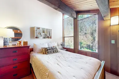 a bedroom with a bed with a dresser and a window at Serene Escape in Kings Beach