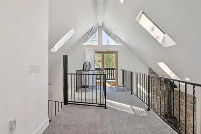 a staircase in a house with a skylight at Spacious Pine Mountain Lake Cabin Rental with Decks in Groveland