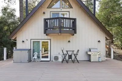 a house with a deck with a grill and a balcony at Spacious Pine Mountain Lake Cabin Rental with Decks in Groveland