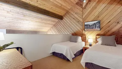 a bedroom with two beds in a wooden ceiling at Snowcreek III #452 condo in Mammoth Lakes