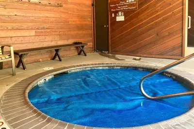 a hot tub with a hose in a room with a bench at Meadow Ridge 34 in Mammoth Lakes