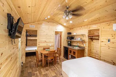 a bedroom with a bed and a desk in a cabin at Jellystone Park Tower Park Resort in Lodi