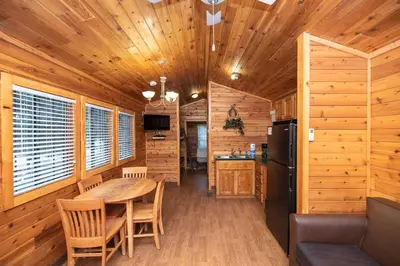 a dining room and kitchen in a log cabin at Jellystone Park Tower Park Resort in Lodi