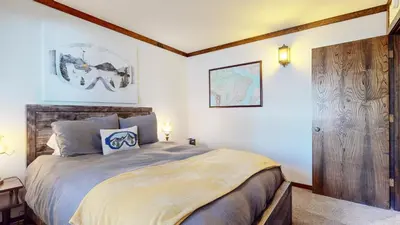 a bedroom with a large bed and a wooden door at Lakeview Lodge #2 condo in Mammoth Lakes