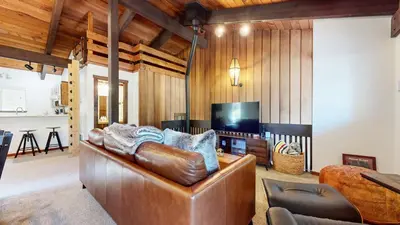 a living room with a leather couch and a television at Lakeview Lodge #2 condo in Mammoth Lakes
