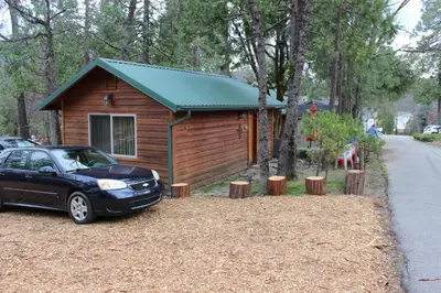 a small cabin with a car parked in front of it at Stewart Chalet @ Yosemite/Bass Lake in Bass Lake