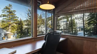 a chair sits at a desk in a room with windows at Mt. Jola by AvantStay A 5-minute walk away to Palisades and lifts. in Olympic Valley