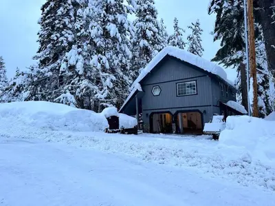 a house covered in snow next to a road at Tahoe Vista Home w/ Spa close to Northstar & Lake in Tahoe Vista
