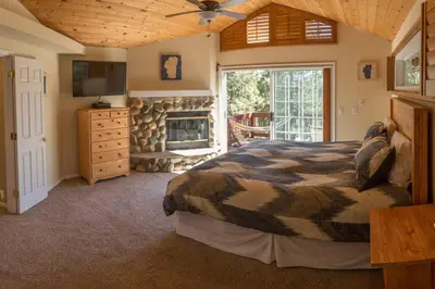 a bedroom with a large bed and a fireplace at Tahoe Vista Home w/ Spa close to Northstar & Lake in Tahoe Vista