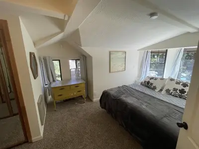 a bedroom with a bed and a dresser and windows at Walking Distance To The Lake And Beach! in Kings Beach