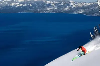 a person skiing down a snow covered slope next to the water at Tahoe Snowbird Retreat in Stateline
