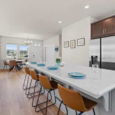 a large white kitchen with a long table with chairs at Newly Built Murphys Modern Retreat in Murphys