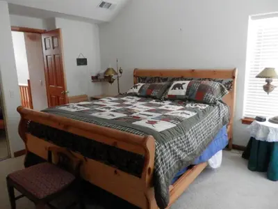 a bedroom with a wooden bed with a quilt on it at Rr-hideaway_down_canyon110 in June Lake