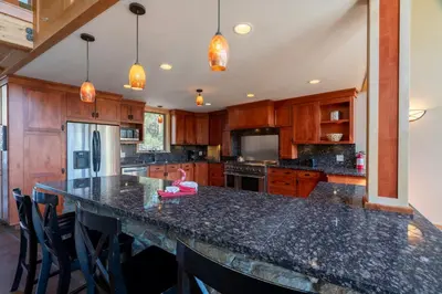 a kitchen with wooden cabinets and a black counter top at Rr-carson_view1 Strap18-005 in June Lake