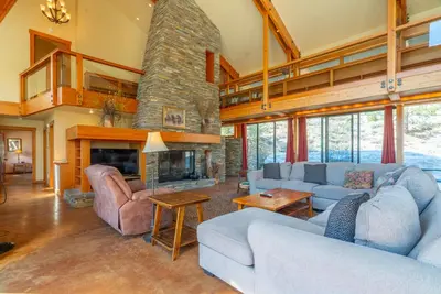 a living room with couches and a stone fireplace at Rr-carson_view1 Strap18-005 in June Lake