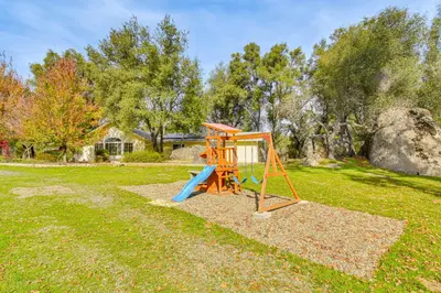 a playground with a slide in a yard at Private Lake, Hot Tub and EV Charger Mariposa Home! in Mariposa