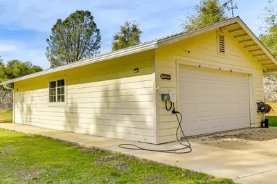a yellow garage with a phone next to it at Private Lake, Hot Tub and EV Charger Mariposa Home! in Mariposa