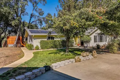 a white house with a tree and a driveway at Private Lake, Hot Tub and EV Charger Mariposa Home! in Mariposa